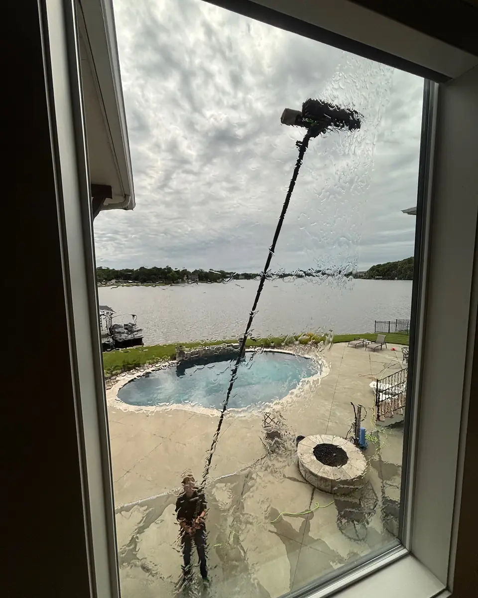 Water-fed pole brush cleaning an upper window from the ground